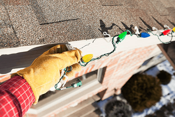 Christmas lights being installed on a roofline